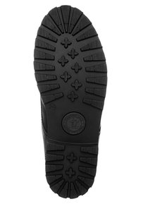 Suela de bota de goma negra con surcos profundos y un logo circular. El patrón incluye formas de cruz en relieve y ranuras diagonales para tracción.