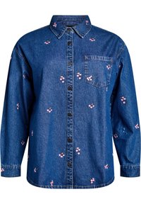 Camisa de denim de manga larga, con botones en la parte delantera y un cuello puntiagudo. Presenta bordados florales en rosa y un único bolsillo en el pecho.