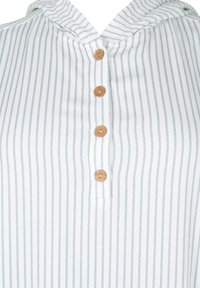 Chemise à capuche avec rayures verticales blanches et vertes, dotée de cinq boutons en bois le long de la patte de boutonnage avant et d'une texture de tissu douce.