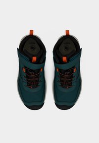 Τυρκουάζ αδιάβροχα παπούτσια με μαύρες λεπτομέρειες, πορτοκαλί κορδόνια και επενδυμένο περιλαίμιο. Διαθέτουν υφή επιφάνειας και ασφαλή ιμάντα.