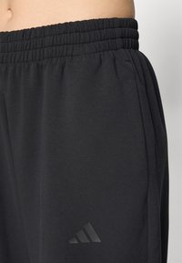 Svarte treningsshorts med elastisk midjebånd, laget av mykt materiale. Har en subtil preget logo på venstre lår.