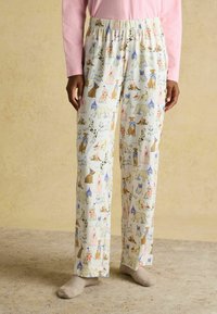 Mehki, ohlapni pižamski hlače v krem barvi z igrivim vzorcem psov, z elastičnim pasom in ravnim krojem.