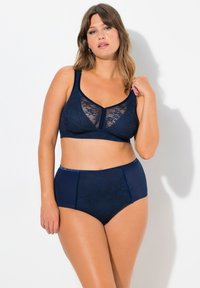 Reggiseno in pizzo navy con pannello trasparente e spalline larghe, abbinato a una culotte alta con dettagli in pizzo coordinati e tessuto morbido.