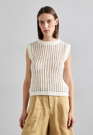 Knit sleeveless top in cream with open mesh design, ribbed neckline and hem. Paired with light beige wide-leg trousers.