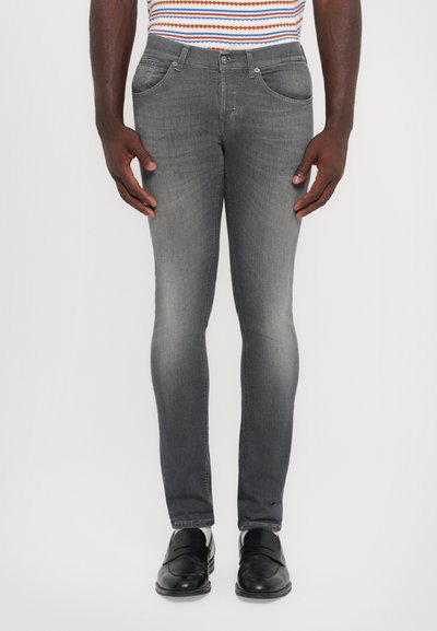 Jeans slim fit grigi in denim, con design a cinque tasche, sfumature delicate e dettagli usurati. Abbinati a mocassini neri.