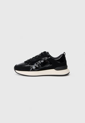 Baskets basses noires avec des panneaux en vernis et en daim, lacets noirs, détail du logo sur le côté et semelle blanche rembourrée.