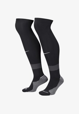 Schwarze knielange Socken mit gerippter Textur, ausgestattet mit einem grauen horizontalen Streifen und einem gestreiften Muster am Fuß. Dezentes Logodesign vorhanden.