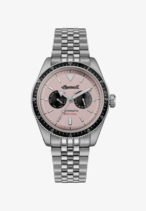 Srebrny metalowy zegarek na rękę z różową tarczą, czarną bezelką, subtarczami do wskazywania dnia i daty oraz luminescencyjnymi znacznikami godzin i wskazówkami.