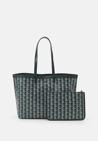 Borsa a spalla e pochette coordinata in verde scuro con motivo geometrico bianco. Realizzate in materiale resistente, presentano manici piatti e chiusura con zip.