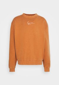 Sudadera de cuello redondo de manga larga en color naranja con puños y dobladillo acanalados, que presenta un pequeño logo en cursiva blanca centrado en el pecho.