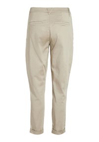Pantaloni in cotone beige con gamba affusolata, dotati di tasche posteriori, orli arrotolati e una superficie liscia.