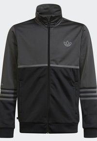 Černá a šedá zipová bunda s vysokým límcem, texturovanou tkaninou, horizontálními pruhy a logem na horní levé části hrudi.