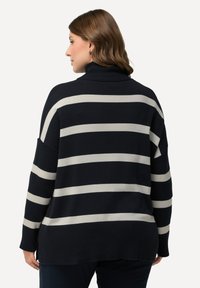 Schwarz- und cremefarben gestreifter Rollkragenpullover mit lockerer Passform, gerippter Textur und seitlichen Schlitzen am Saum für optimale Bewegungsfreiheit.