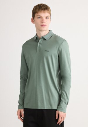 Long-sleeve polo shirt in muted green cotton with a two-button placket, featuring a small black logo on the left chest.