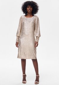Sukienka z złotych cekinów z długimi, bufkami na rękawach i zaokrąglonym dekoltem. Prosty krój sięga tuż nad kolano. Gładka faktura z pionowym wzorem cekinów.