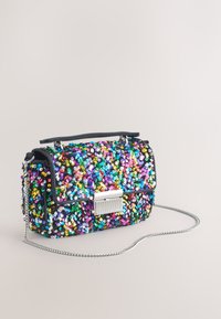 Rankinė, padengta blizgučiais, juodos odos apdaila, stačiakampės formos, sidabrinė metalinė detalė, nuimamas grandinėlės dirželis per petį.