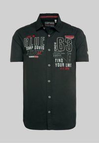 Černá košile s krátkým rukávem na knoflíky, která obsahuje různé textové prvky v bílé a červené barvě. Vyrobena z lehké látky, s límcem a standardním střihem.