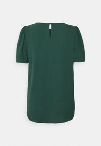 Blouse verte foncée à manches courtes avec épaules bouffantes et fermeture à bouton clé à l'arrière du col.