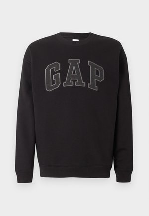 Svart genser med lange ermer og rund hals, med store mørkegrå "GAP" bokstaver brodert på brystet.