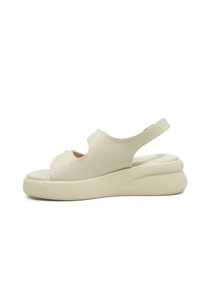 Sandala krem boje s otvorenim prstima, debelim potplatom i remenom oko pete, gornji dio od glatke kože, bočni pogled na bijeloj pozadini.