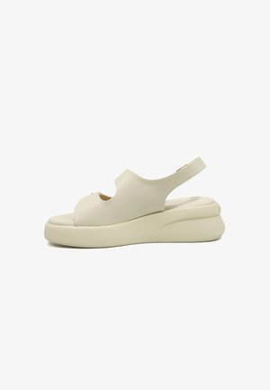 Roomkleurige sandaal met open teen, dikke plateauzool en slingback-strap, gladleren bovenwerk, zijaanzicht op witte achtergrond.