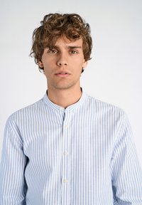 Camicia a righe blu chiaro e bianco con colletto a fascia e chiusura con bottoni. Tessuto di cotone morbido con design slim fit.