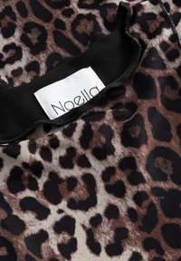 Tessuto con stampa leopardata, colletto nero e etichetta bianca con il nome del marchio "Noella".