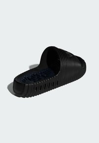 Sort slidssandal lavet af tekstureret gummi med et buet design og ribbet detaljering på overfladen. Indersiden er blå og polstret.