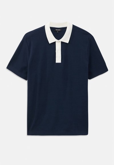 Mørkeblå polo-skjorte med hvit krage, korte ermer og knappestolpe. Laget av glatt stoff med minimal tekstur.