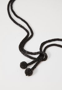 Black beaded necklace with two strands, featuring small round tassels made of intricate beadwork, creating a textured surface.
