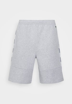 Shorts gris clair longueur genou avec taille élastique et bandes latérales comportant le texte du logo de la marque en bleu foncé.