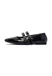Shoe flat in pelle verniciata nera con punta affusolata, dotato di due cinturini regolabili con hardware circolare e una finitura liscia e lucida.