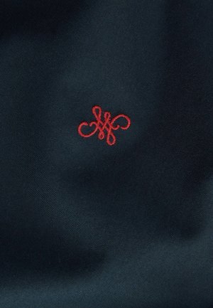 Țesătură de culoare bleumarin cu un design monogramat brodat în roșu, prezentând bucle și forme complexe. Textură netedă, model compact și strâns țesut.