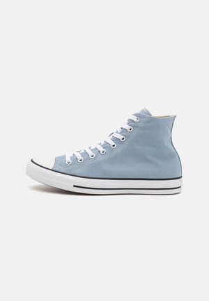 Baskets montantes en toile bleu clair avec lacets blancs, semelle en caoutchouc blanche et détails rayés noirs, vues de côté sur fond blanc.
