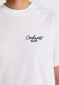 White cotton t-shirt with a crew neckline and short raglan sleeves; features black embroidered "Carhartt WIP" logo on the left chest.
