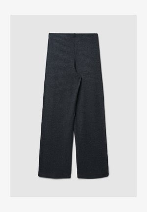 Spodnie o szerokich nogawkach w ciemnoszarym żebrowanym materiale, z wysokim stanem i płaskim przodem, bez widocznych kieszeni czy zapięć.