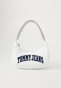 Balta sintetinė rankinė kreivai forma, sidabrinė grandinėlė ir tamsiai mėlyna siuvinėta "TOMMY JEANS" tekstas priekyje. Lygus paviršius.