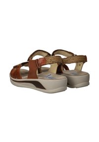 Brown leather sandals with woven accents, open design, adjustable straps, and a cushioned beige sole for comfort and stability.