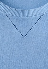 Encolure de pull en tricot bleu clair avec col côtelé et motif décoratif en forme de V ajouré sous le col.