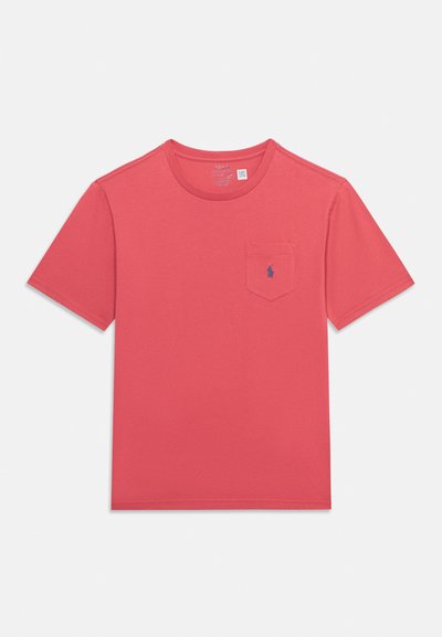 T-shirt rouge uni à manches courtes et col rond avec une petite poche poitrine comportant un logo subtil de joueur de polo bleu.