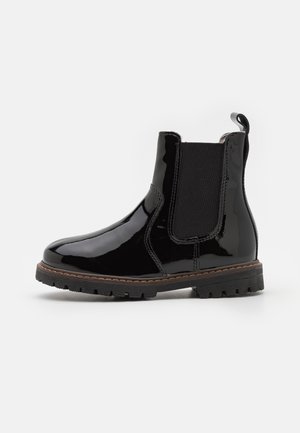 Botte Chelsea en cuir noir brillant avec panneau latéral élastique, languette à l'arrière et semelle robuste avec détail de surpiqûre marron.