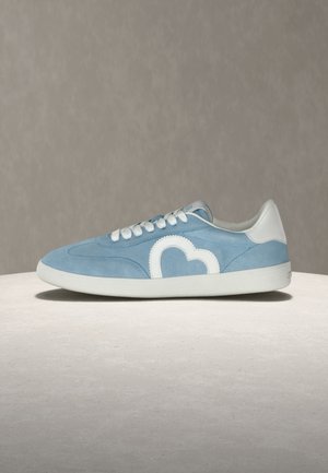 Baskets en daim bleu clair avec des lacets blancs, une semelle blanche, un renfort de talon blanc et un motif en forme de cœur blanc sur le côté.