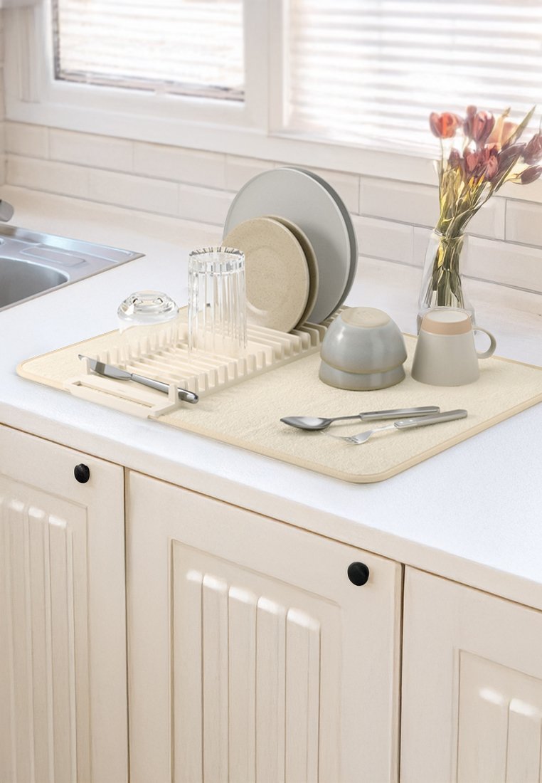 Beige Geschirrabtropfmatte mit einer strukturierten Oberfläche, auf der Teller, Gläser und Besteck ordentlich angeordnet sind. Enthält einen Abtropfrack und eine Blumenvase.