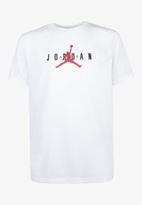Vit bomullströja med rund halsringning, som har en röd silhuettlogotyp och svart text med ordet "JORDAN" över bröstet.