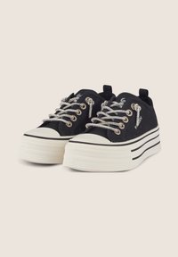 Sneakers neri in tela con accenti bianchi, suola piatta spessa, occhielli in tonalità argento e lacci metallici. Punta arrotondata e strisce a contrasto.