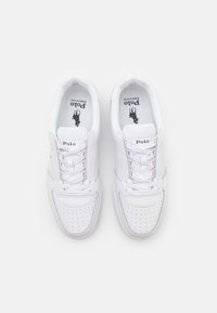 Sneakers atletici bianchi con tomaia in pelle liscia, punta perforata, lacci piatti e logo stampato sulla linguetta.