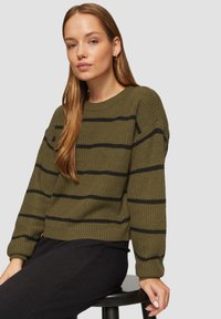 Olijfgroen gebreid sweater met zwarte horizontale strepen, met een ronde halslijn en een relaxte pasvorm, weergegeven boven een zwarte onderkant.
