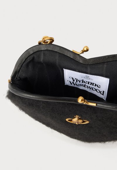 Μαύρο υφασμάτινο clutch Vivienne Westwood με χρυσό κούμπωμα και λογότυπο, που δείχνει ανοιχτό εσωτερικό και λευκή ετικέτα σχεδιαστή στο εσωτερικό.