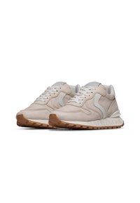 Sneaker in suede beige con accenti in pelle bianca, lacci rotondi e suola di gomma testurizzata con battistrada visibile. Nome del marchio sul tallone.