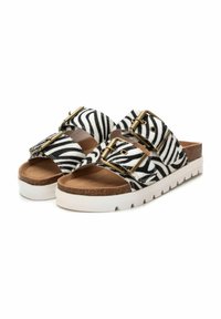 Sandalias de estampado de cebra en blanco y negro con dos correas anchas y hebillas doradas. Plantilla de corcho sobre una suela de plataforma blanca texturizada.